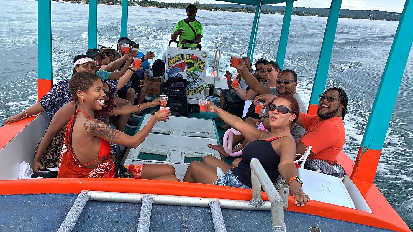 Guests raising a toast aboard an orange and teal boat